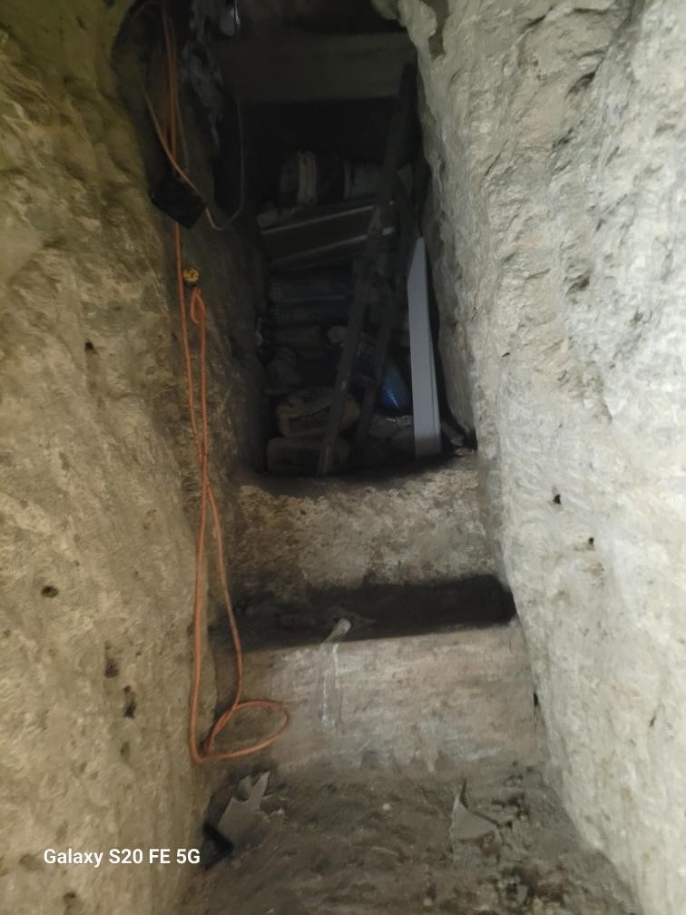 Inside the passage: reinforced walls, power lines and a ladder leading down to the cargo route.